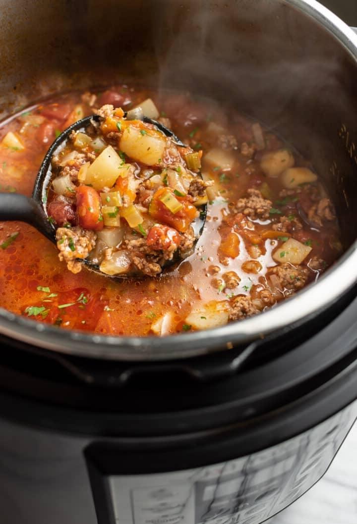 Ein Instant Pot mit einer Schöpfkelle Rinderhackfleischsuppe