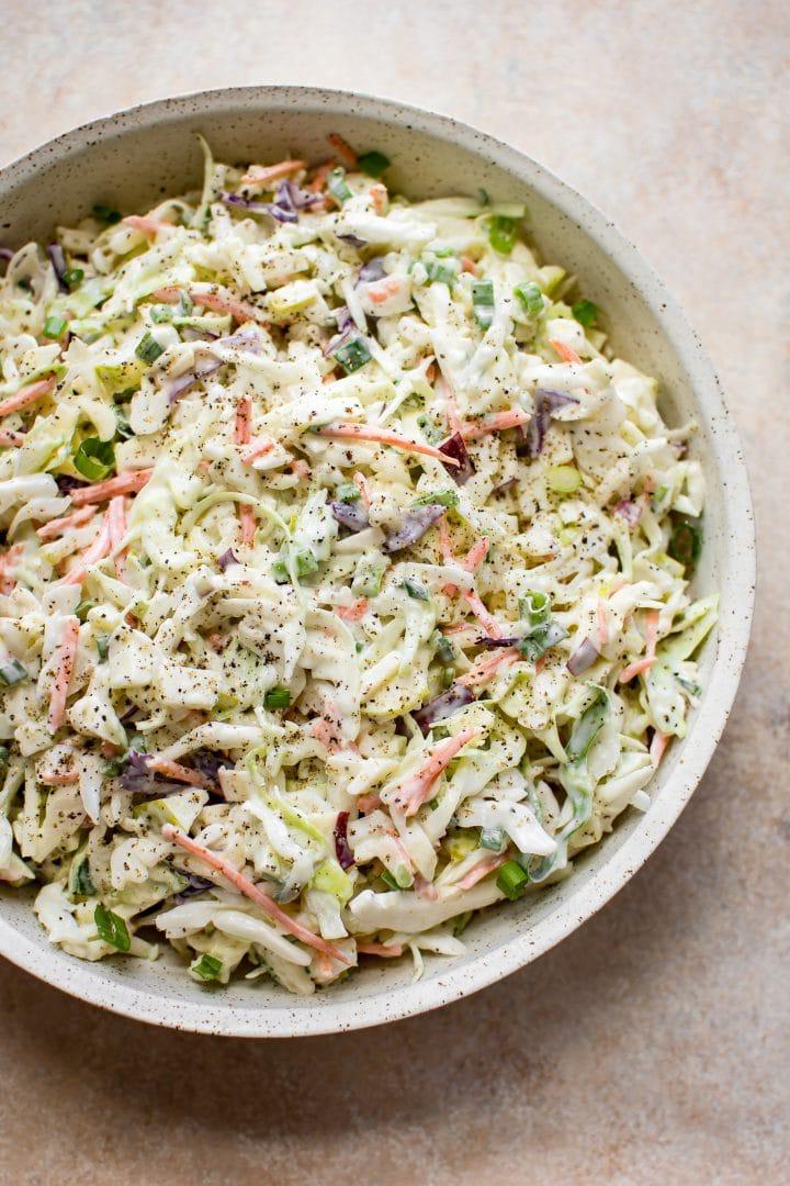 Einfacher Apfel-, Kohl- und Karottensalat in einer beigen Schüssel