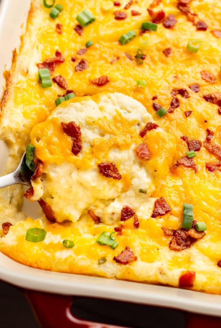 Reichhaltiger Kartoffelpüree-Auflauf 2 close-up of a serving spoon in a baking dish with loaded mashed potato casserole