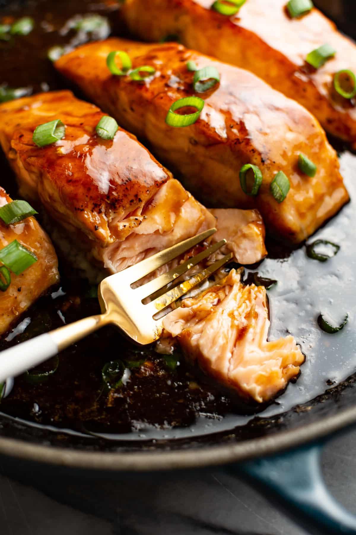 **Ahorn-glasierter Lachs** 2 Gegrillter Lachs mit Ahornglasur auf einem Teller mit Gabel, Nahaufnahme