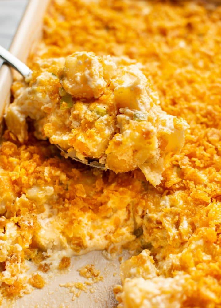 Beerdigungskartoffeln 2 Ein Löffel voll Funeral Potatoes wird aus einer Auflaufform gehoben – Nahaufnahme
