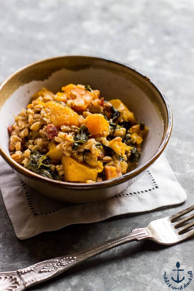 a bowl of baked farro with butternut sqaush, pancetta, and kale and a fork