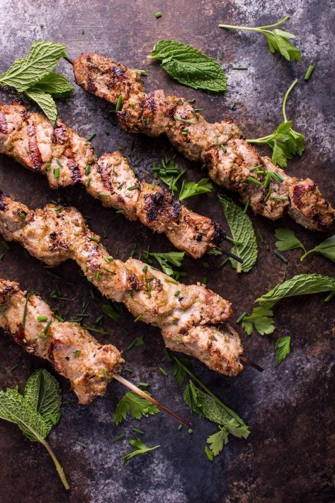 vier gegrillte vietnamesische Zitronengras-Schweinefilet-Spieße mit Minzdekoration