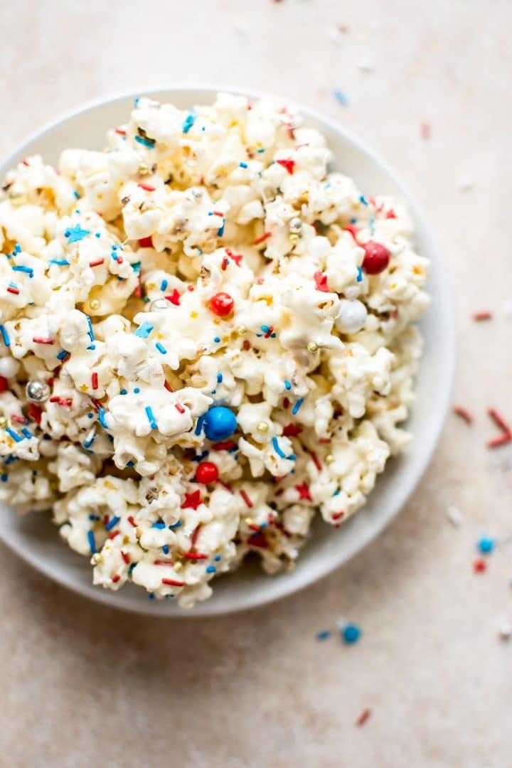 Popcorn, beträufelt mit Marshmallows und rot-weiß-blauen Streuseln in einer Schüssel