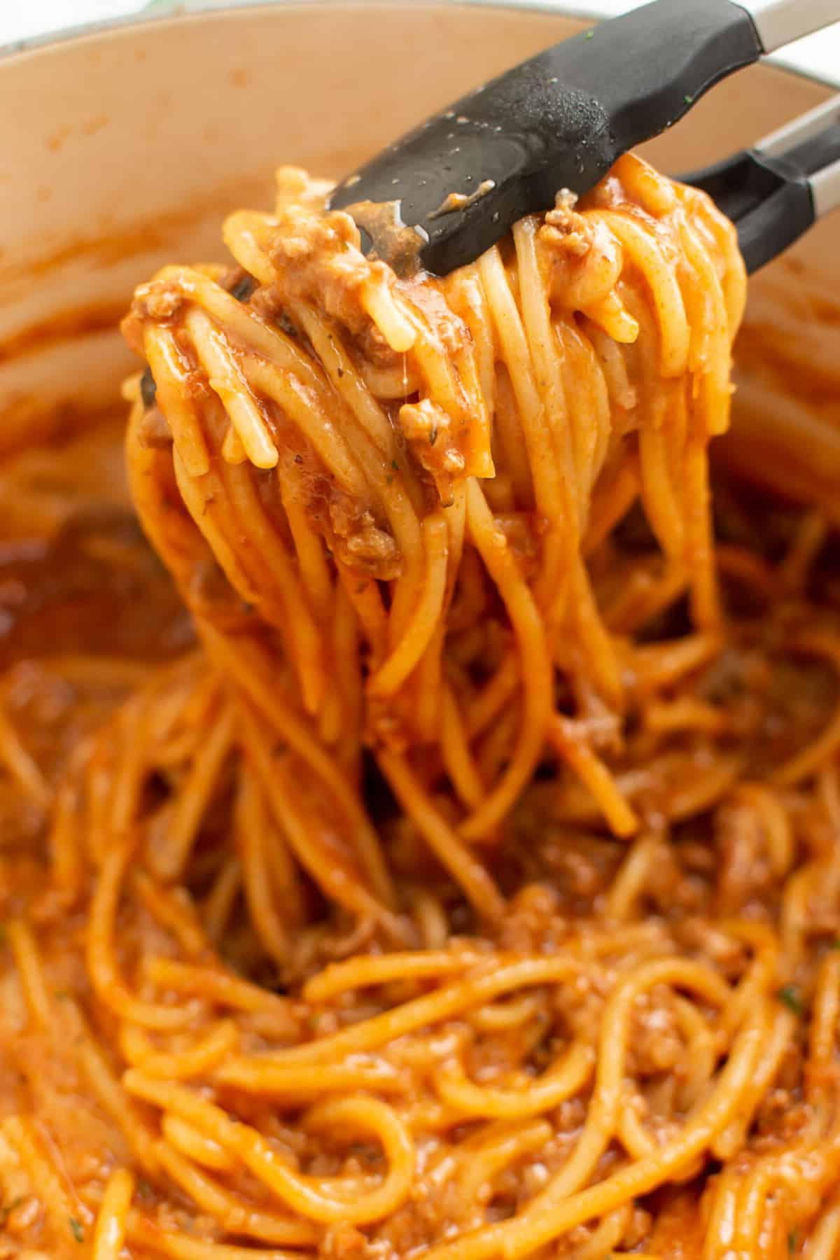 Closeup von One-Pot Spaghetti mit Küchenzange