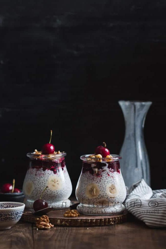 creamy chia seed breakfast pudding in two glasses topped with cherries