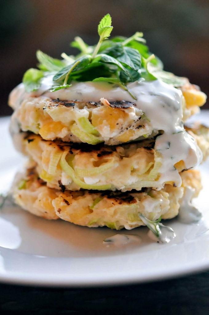close-up of stack of three corn leek fritters with herb yogurt