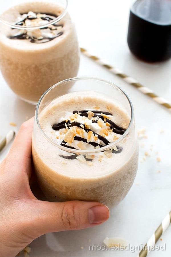 hand holding glass of coconut coffee homemade frappuccino