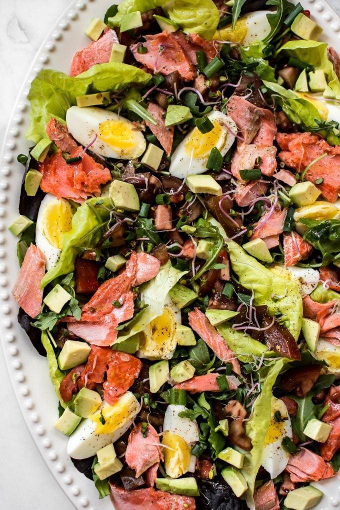 Nahaufnahme eines leichteren Lachs Cobb Salat Rezepts auf ovaler Platte