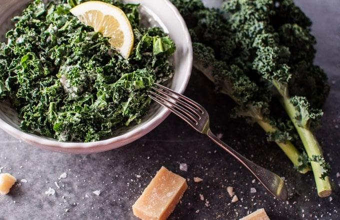 Nahaufnahme einer Schale mit Grünkohlsalat, Parmesan, Zitrone und schwarzem Trüffelöl