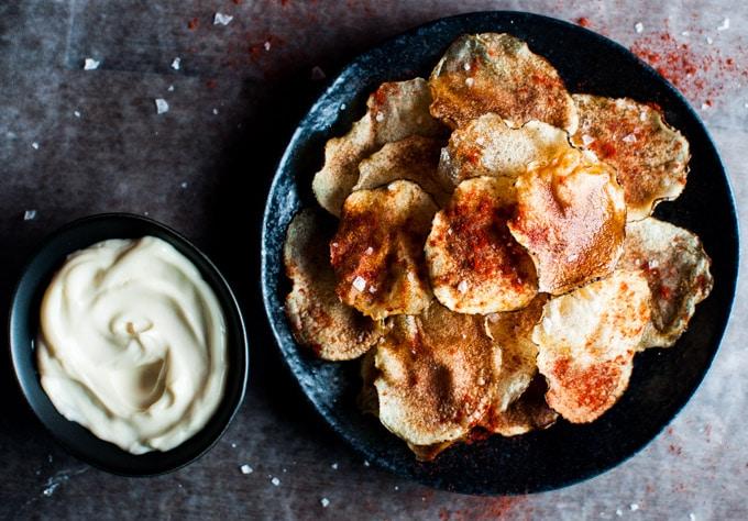 Schüssel mit kleinen Mikrowellen-Chips mit Meersalz, Paprika und Olivenöl mit kleiner Schüssel Trüffel-Mayonnaise-Dip