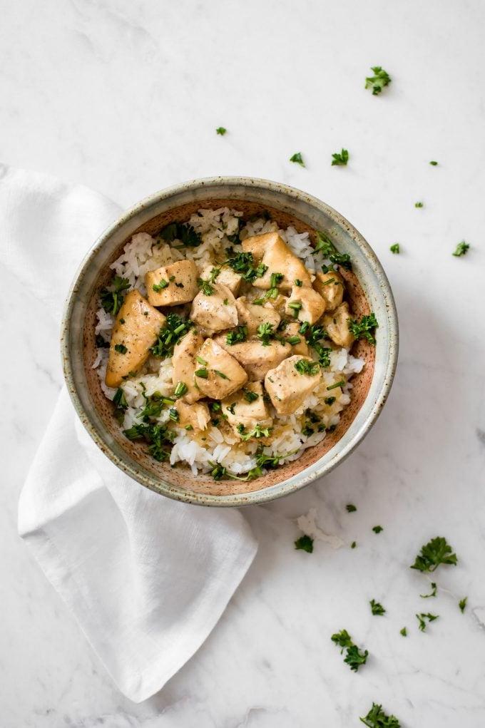 Schüssel mit Instant Pot Honig-Knoblauch-Hähnchen mit weißer Stoffserviette daneben