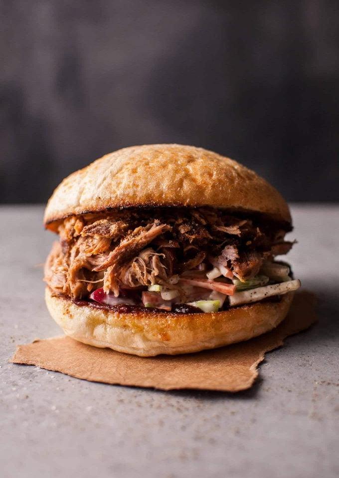 a close-up of a slow cooker pulled pork sandwich with crunchy apple slaw in a bun