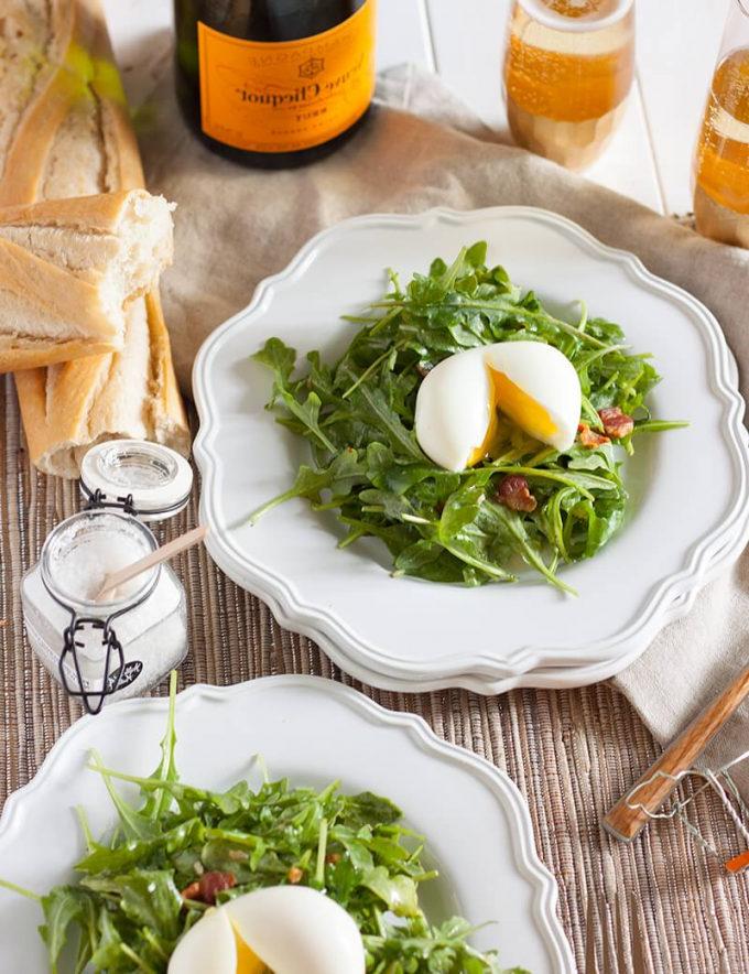 salad lyonnaise on plates with baguette and champagne