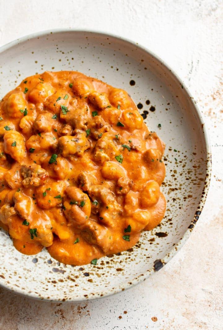 Nahaufnahme von Käse-Gnocchi mit Bratwurst in einer flachen Schale