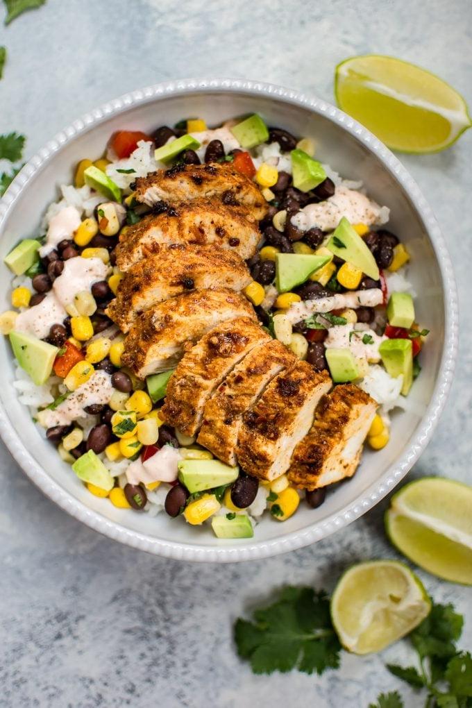 Scharfe Hähnchen Taco Bowl neben Limettenspalten