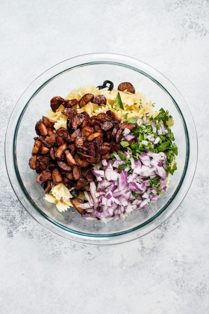 Glasschüssel mit Zutaten für scharfen Chorizo-Nudelsalat