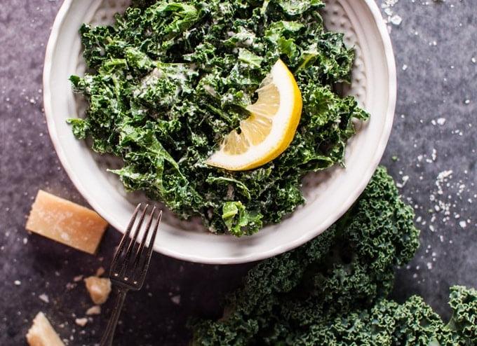 Schale mit Grünkohlsalat, Parmesan, Zitrone und schwarzem Trüffelöl mit einer Gabel