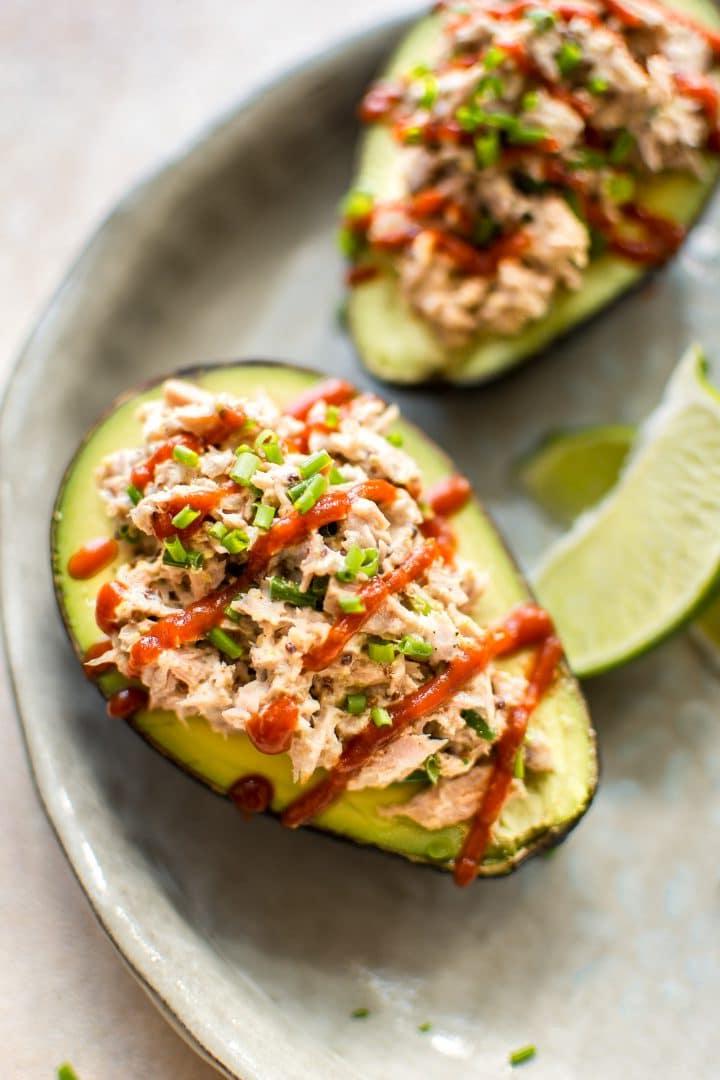Pikante Thunfisch-Avocado mit Sriracha-Guss und Limettenspalten auf einem Teller