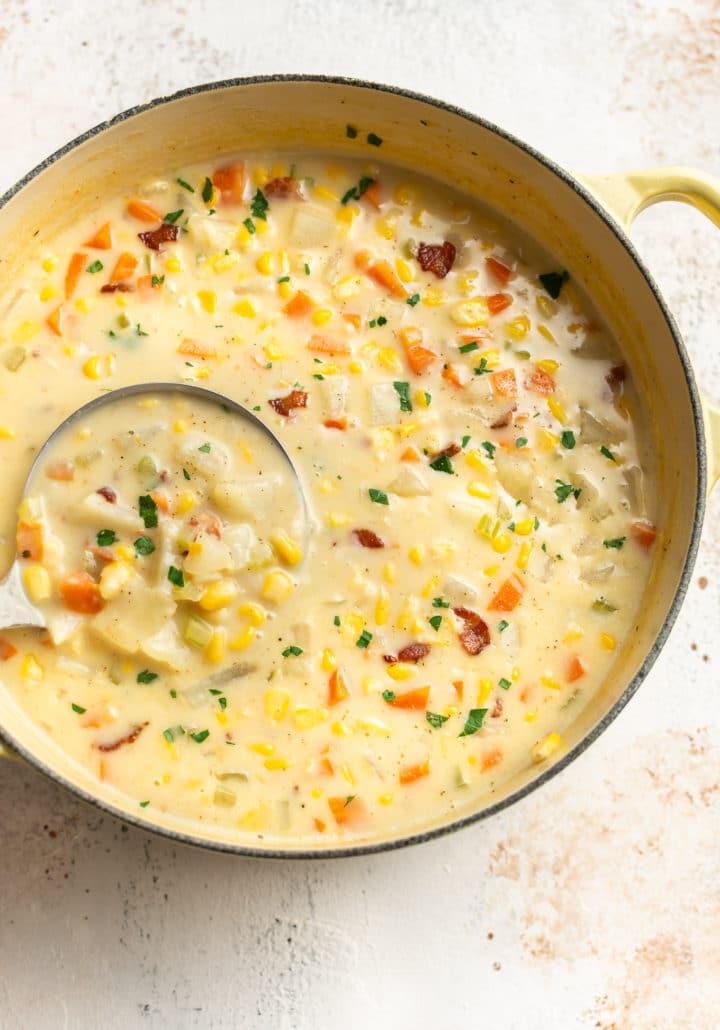 Die beste Mais-Chowder in einem gelben Suppentopf mit einer Kelle
