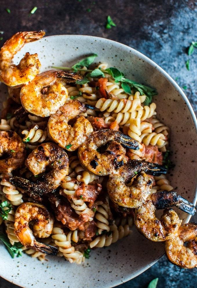 Nahaufnahme einer tiefen Schüssel mit würziger gegrillter Garnelen Pasta, kunstvoll angerichtet und servierfertig.