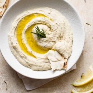Dieser einfache vegane weiße Bohnen-Dip ist mit frischem Rosmarin, spritzigem Zitronensaft, würzigem Knoblauch und hochwertigem Olivenöl angereichert. Er ist ein köstlicher, gesunder und leicht zuzubereitender Dip, perfekt für einen gemütlichen Mädelsabend, einen spannenden Spieleabend oder als elegante Vorspeise.