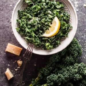 Grünkohlsalat mit Parmesan, Zitrone und Schwarzem Trüffelöl 5 Eine Schale mit Grünkohlsalat, Parmesan, Zitrone und schwarzem Trüffelöl mit einer Gabel
