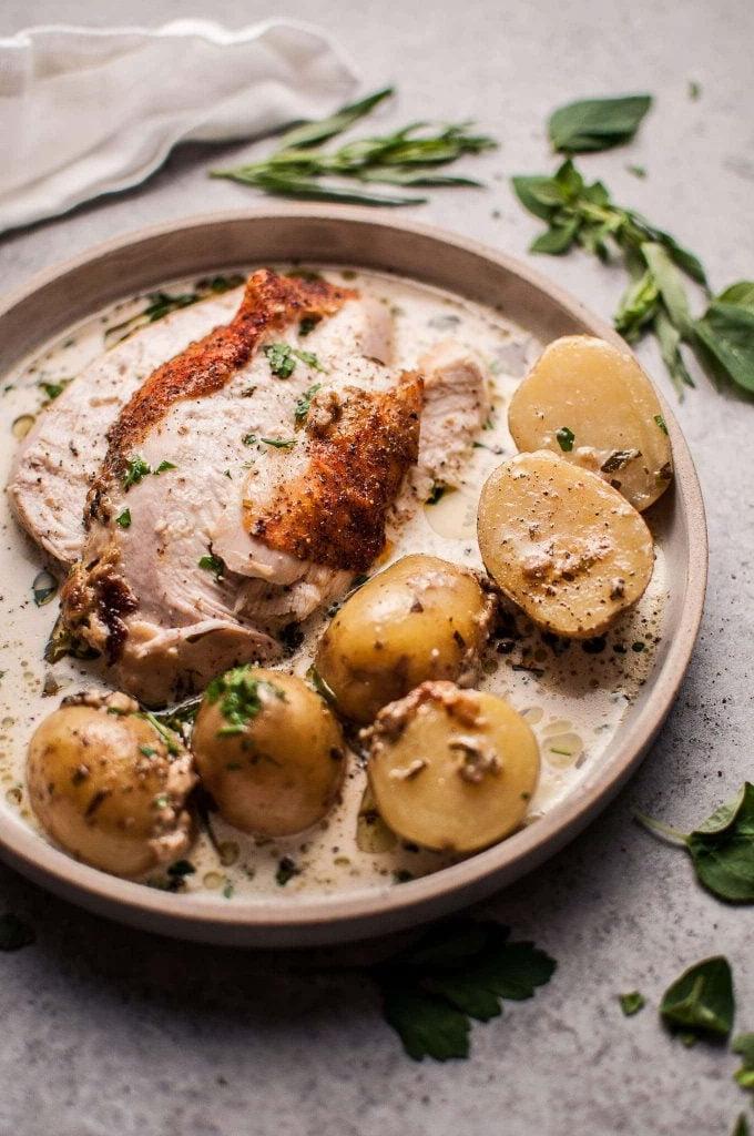 plate of creamy lemon and herb pot roasted chicken with little potatoes