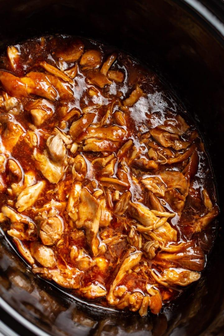 Nahaufnahme von Honig-Knoblauch-Hähnchenschenkeln aus dem Slow Cooker, im Crockpot zerkleinert