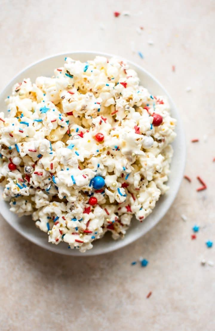 Popcorn für den 4. Juli mit patriotisch gefärbten Streuseln in einer weißen Schüssel