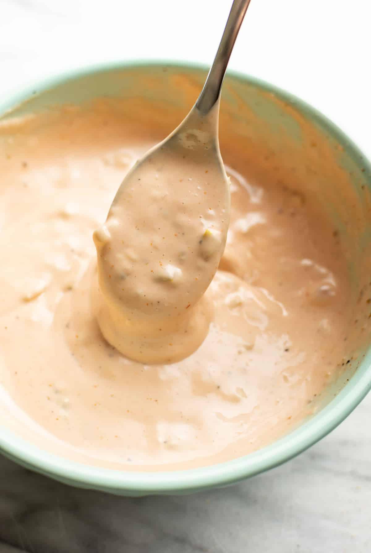 Eine Zubereitungsschüssel mit selbstgemachter Burgersauce und einem Löffel