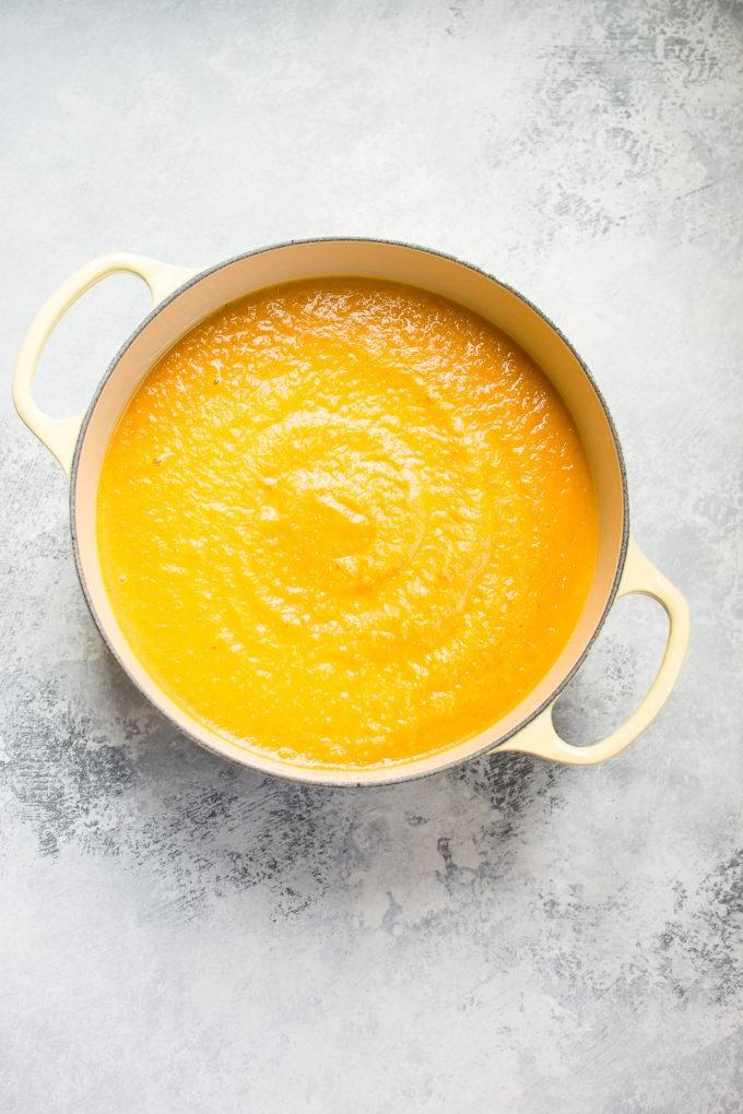 Topf gefüllt mit Eichelkürbis-Karotten-Suppe