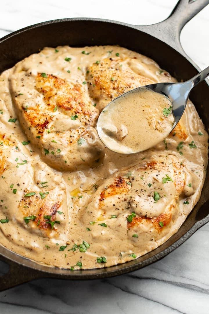 **Pilzrahm-Hähnchen aus der Pfanne** 6 Eine Pfanne mit Hähnchen in Pilzrahmsoße und einem Servierlöffel.