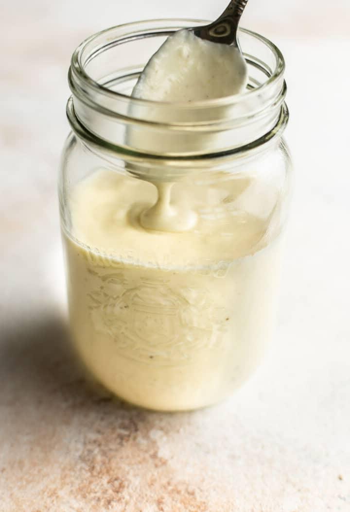 **Schnelle und einfache Alfredo-Soße** 6 a glass jar with alfredo sauce and a spoon