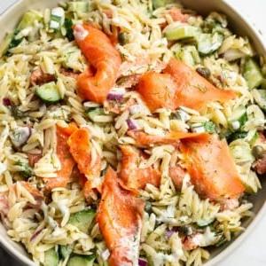 Orzo-Salat mit geräuchertem Lachs in einer beigen Servierschüssel