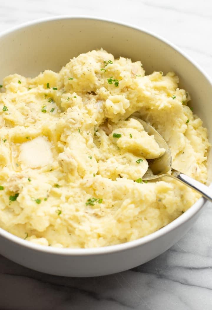 Eine Schüssel Boursin Kartoffelpüree mit einem Servierlöffel