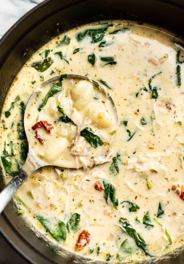 Ein Topf mit Toskanischer Hähnchen-Gnocchi-Suppe und einer Schöpfkelle