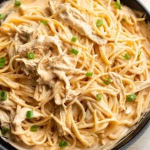 Nahaufnahme von cremiger Buffalo Chicken Pasta (Soße und Spaghetti) in einer Pfanne