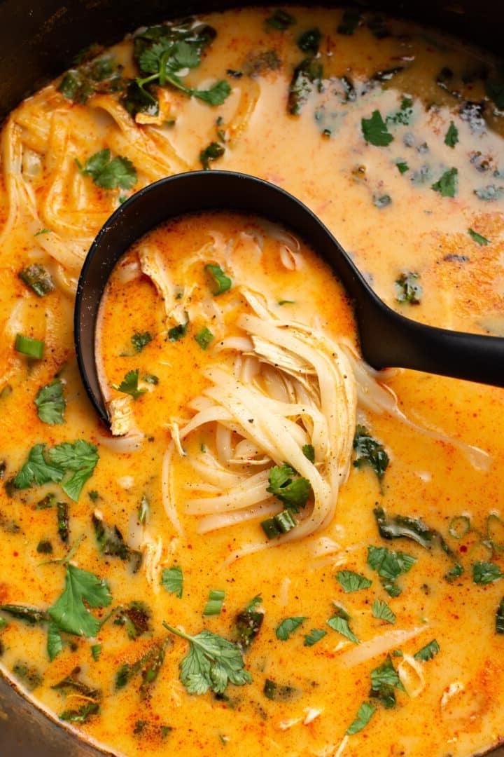Eine Kelle mit Thai Hähnchensuppe
