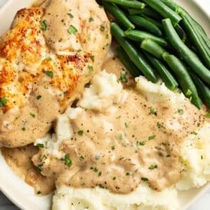 **Pilzrahm-Hähnchen aus der Pfanne** 7 Ein Teller mit Hähnchen in cremiger Pilzrahmsoße, grünen Bohnen und Kartoffelpüree.
