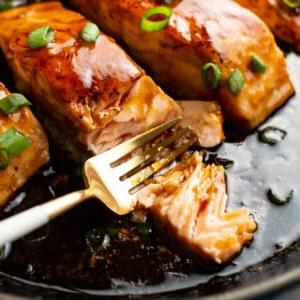 **Ahorn-glasierter Lachs** 7 Gegrillter Lachs mit Ahornglasur auf einem Teller mit Gabel, Nahaufnahme