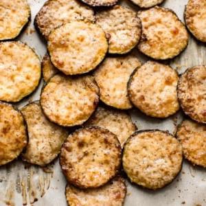 Einfache gebackene Parmesan-Zucchini-Chips mit Knoblauch und Balsamico-Essig. Eine köstliche geröstete Zucchini-Beilage. Diese kleinen Happen sind ein köstlicher Low-Carb Keto-Snack!