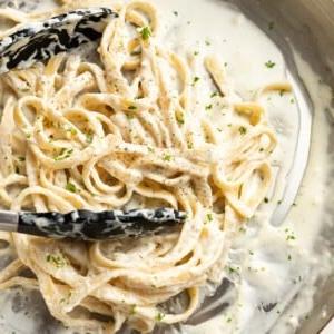 **Schnelle und einfache Alfredo-Soße** 8 a skillet with fettuccine alfredo and serving tongs