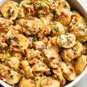 Speck-Kartoffelsalat in einer weißen Servierschüssel