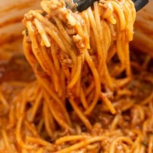 Closeup von One-Pot Spaghetti mit Küchenzange