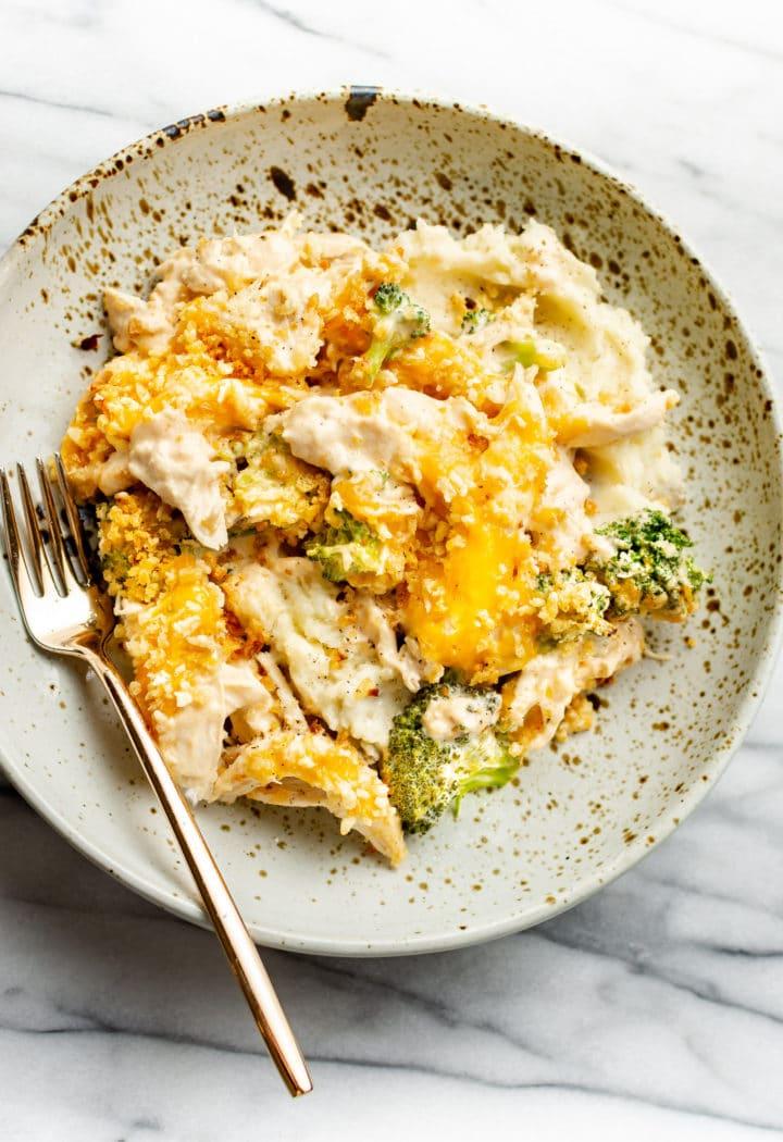 Käse-Hähnchen Divan 9 close-up of a shallow bowl with creamy chicken and broccoli casserole and mashed potatoes