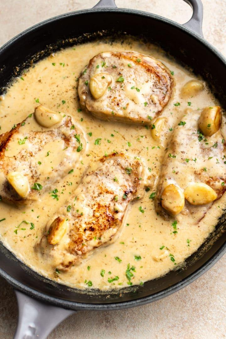 Cremige Knoblauch-Schweinekoteletts 2 cremige Knoblauch-Schweinekoteletts in einer Pfanne