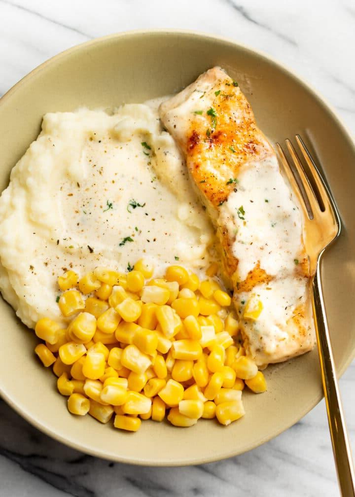 Cremiger Zitronen-Lachs 6 Ein Teller mit Kartoffelpüree, cremigem Zitronen-Lachs und Mais