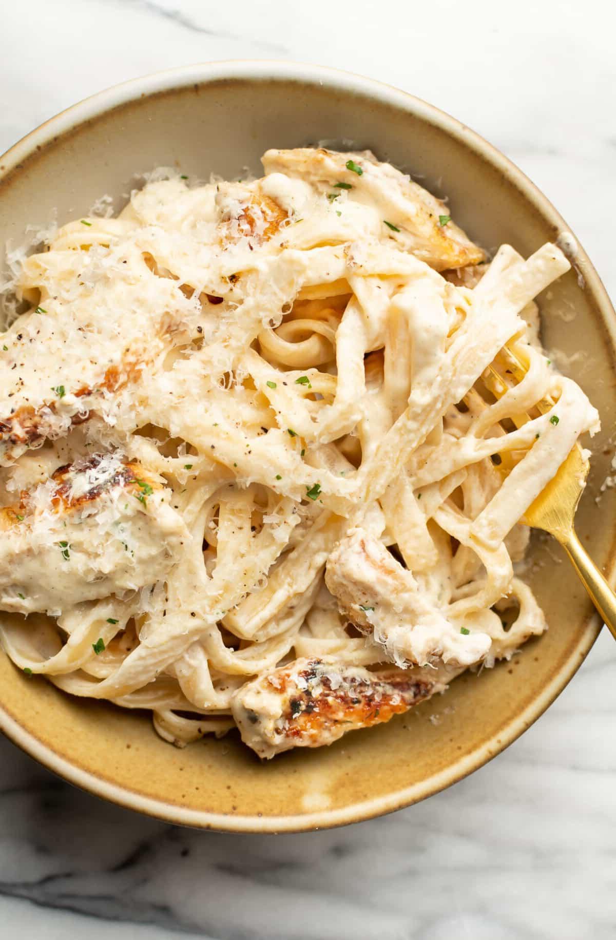 Hähnchen Fettuccine Alfredo 6 Eine Schüssel Hähnchen Fettuccine Alfredo mit einer Gabel