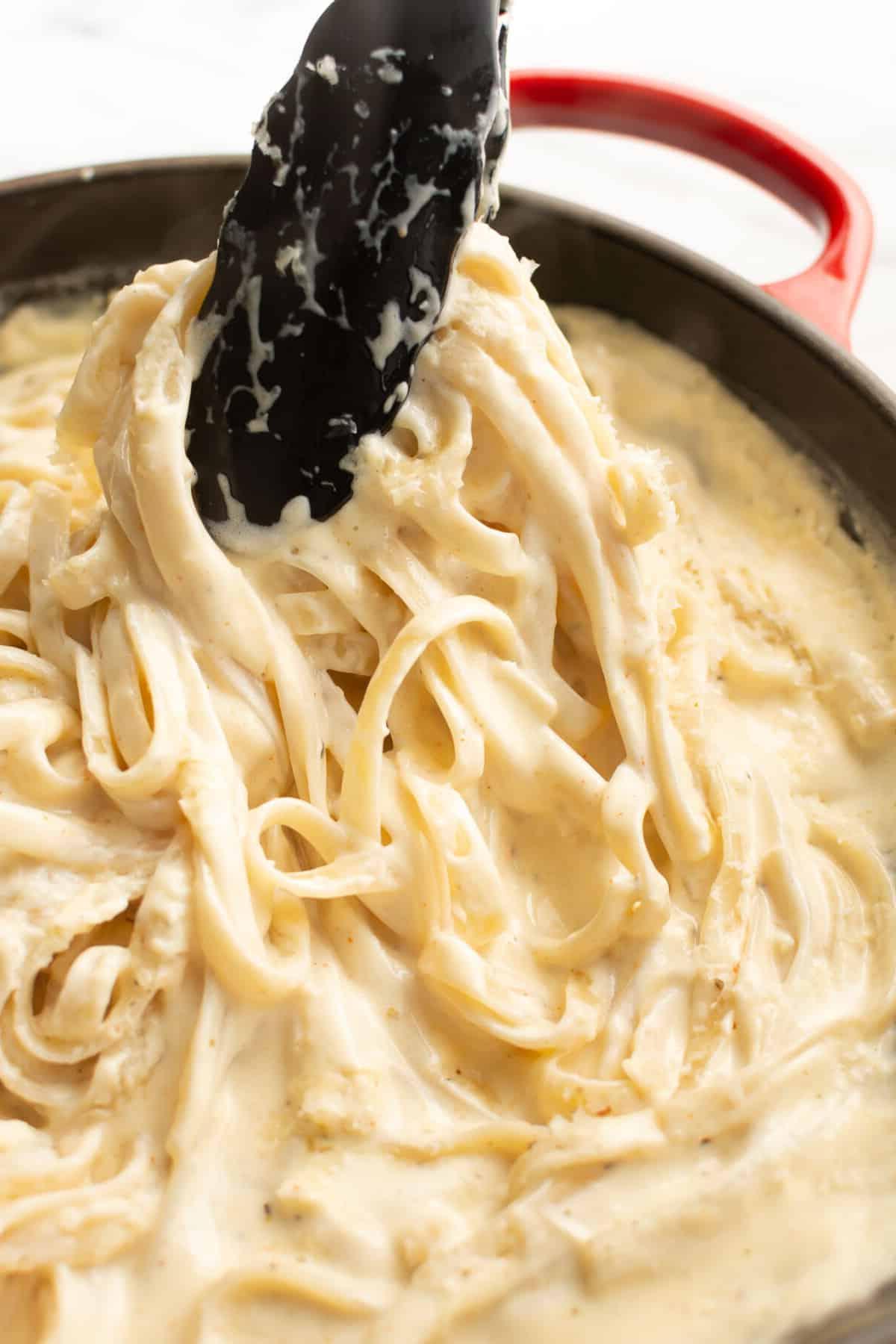 Cajun-Alfredo-Soße 6 Nahaufnahme von Servierzangen mit Cajun Fettuccine Alfredo